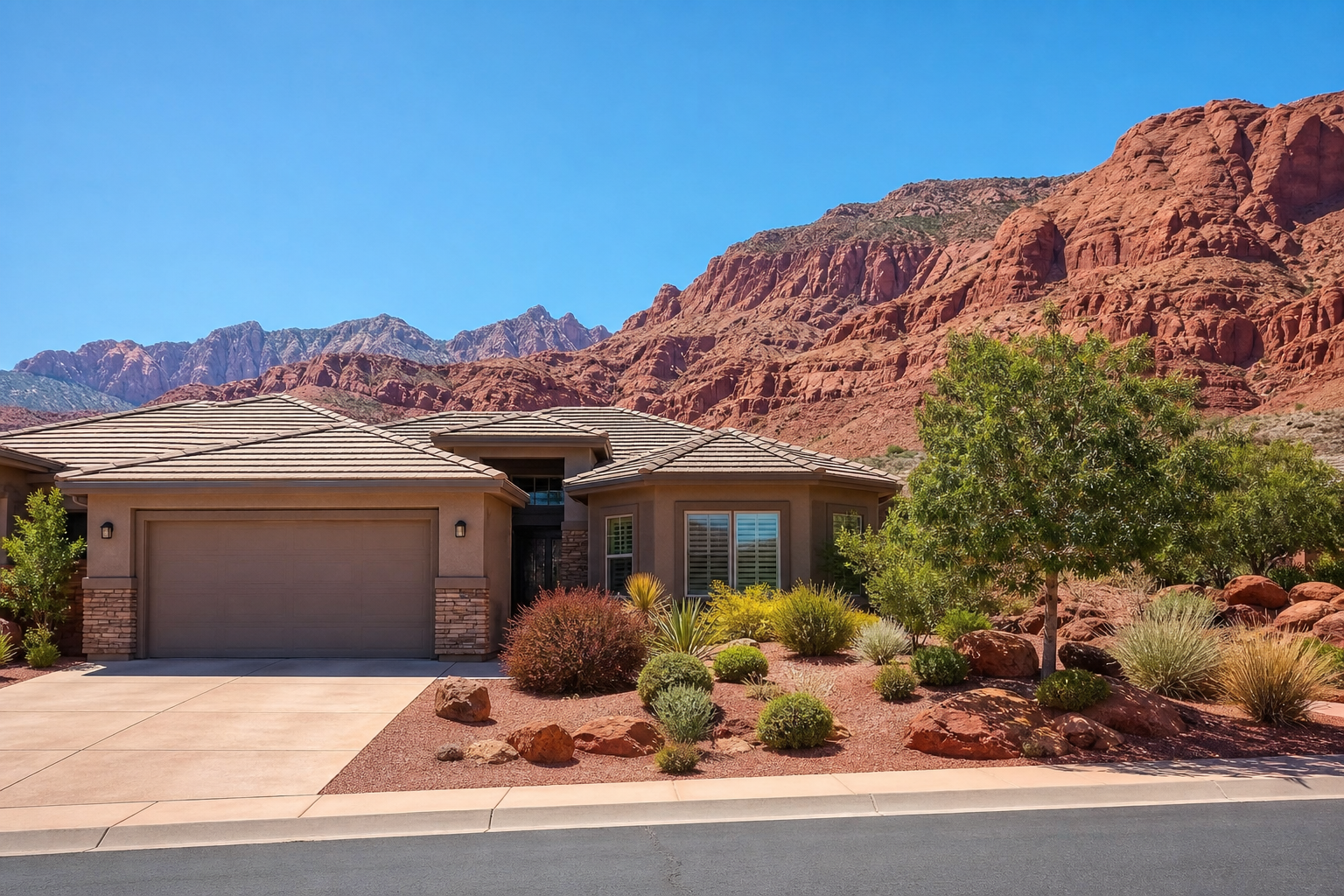 El hermoso exterior de una casa moderna con el impresionante paisaje de rocas rojas del sur de Utah al fondo bajo un cielo brillante y soleado.